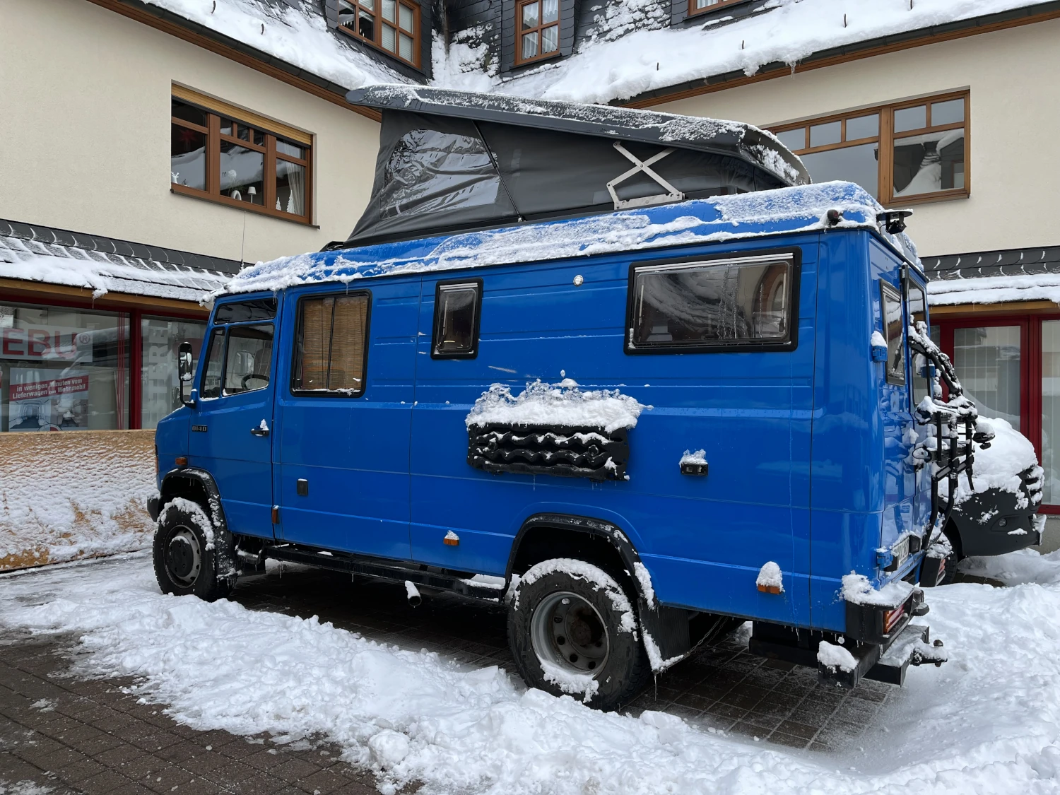 Mercedes Vario in Blau  mit geöffneten Aufstelldach - Seitenansicht